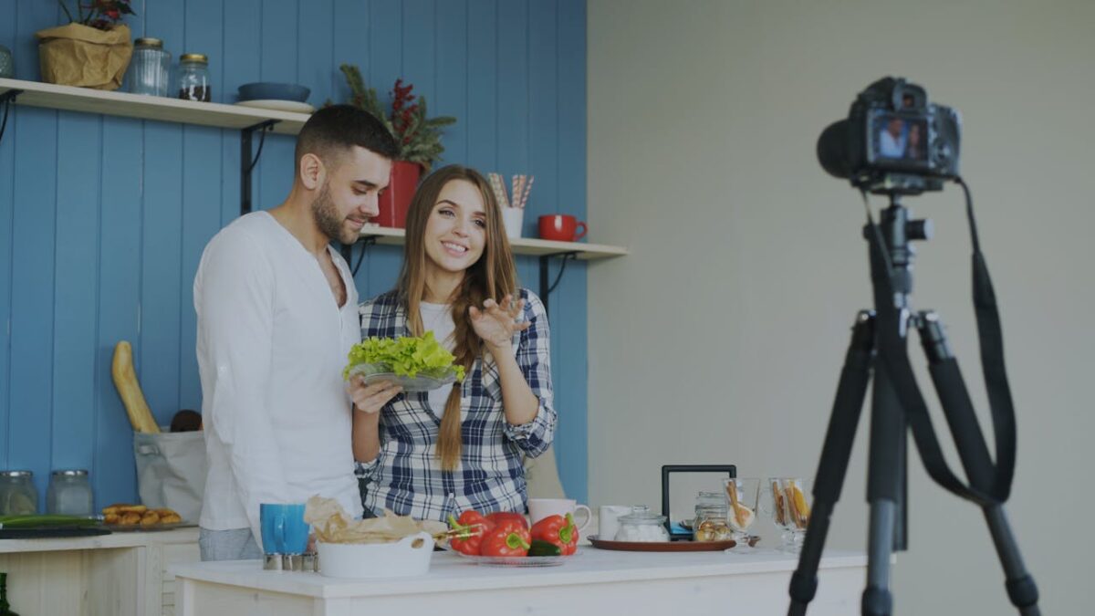 why-choose-us-01 A couple filming a cooking video, showcasing fresh ingredients in a cozy kitchen setting.